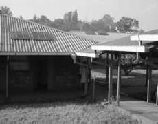 Marriage of high and low technology. Active and passive solar arrays sit atop corrugated metal roofed walkways throughout this district open-air hospital. Photographer: James Li, M.D.